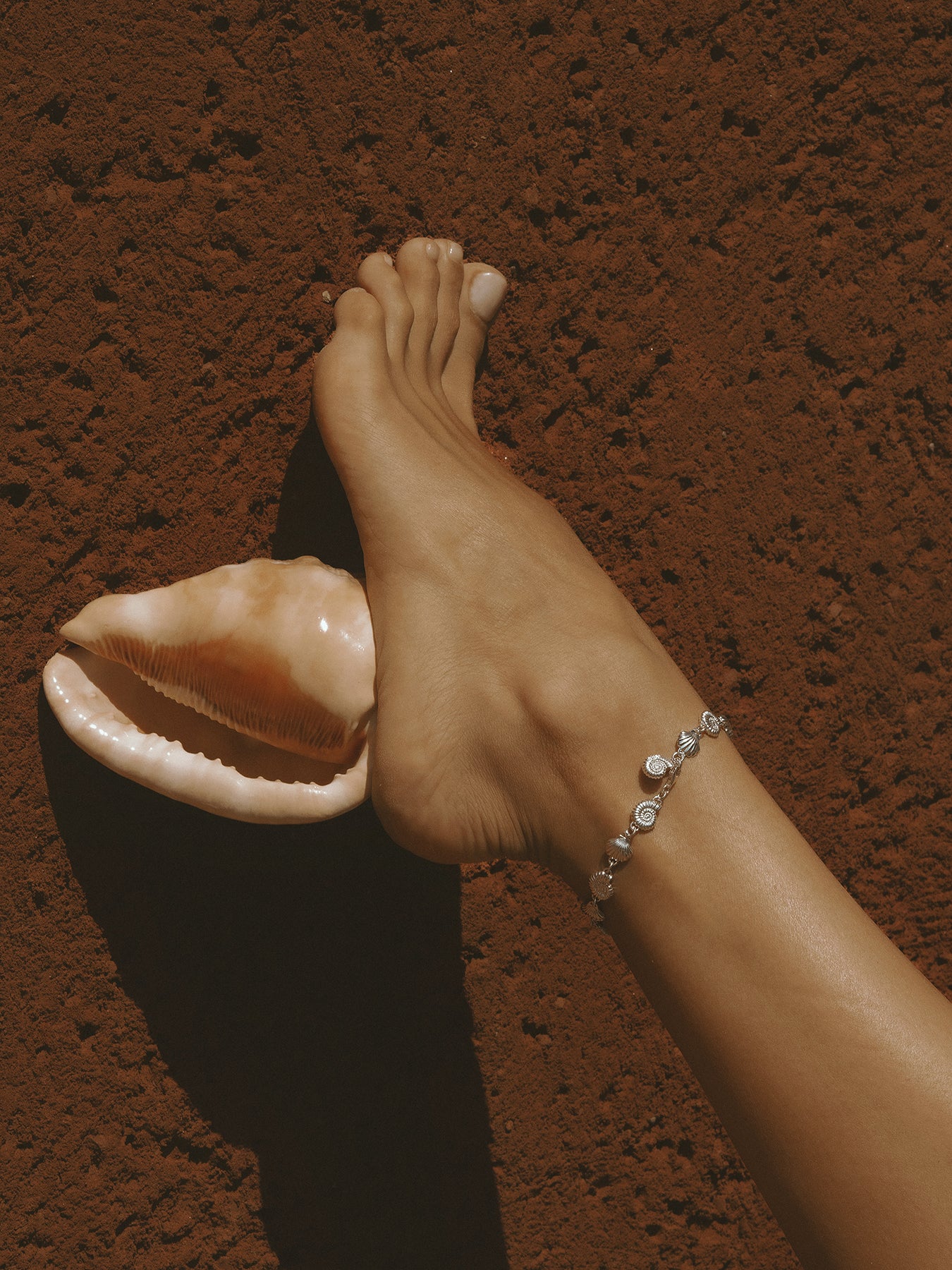The Power of Love Anklet in sterling silver by Pola Jewellery—shells and spirals symbolizing eternal love, movement, and summer energy.