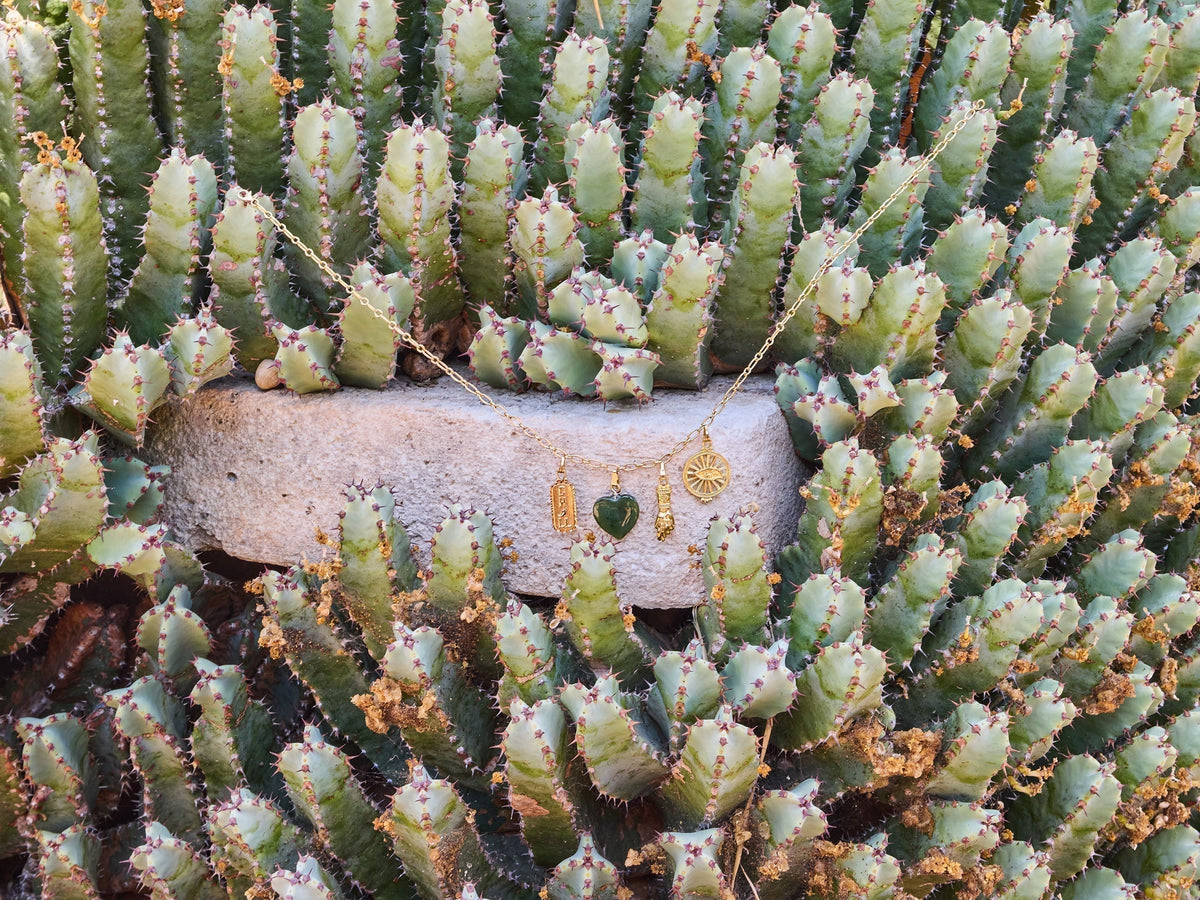 Pola Jewellery Talisman Necklace with Mano Figa, Evil Eye, Chill and Green Jade Heart charms resting on a cactus at Botanicactus Mallorca — handmade talisman jewellery designed in Mallorca handcrafted in Barcelona.