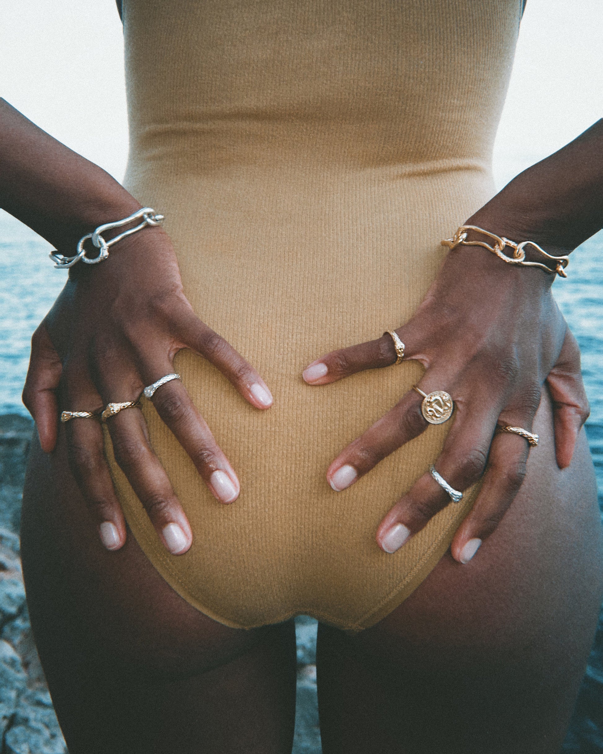 Model wearing multiple Ouroboros Rings in white and yellow gold by Pola Jewellery — solid gold snake ring stack, modern heirloom jewellery designed in Mallorca.