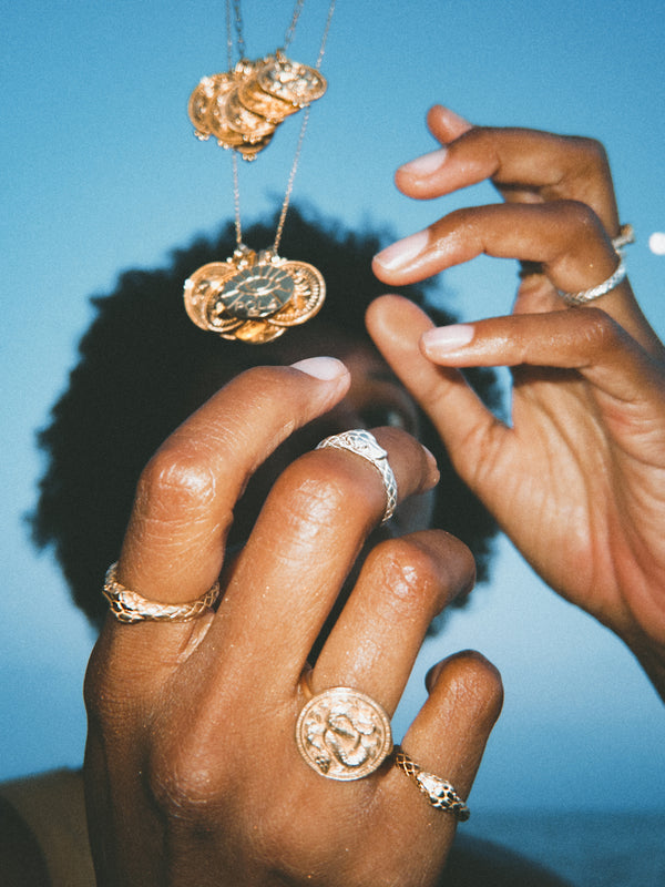 Woman's hand stacked with Ouroboros Rings in solid white and yellow gold by Pola Jewellery — eternal love snake ring set, handcrafted in Barcelona designed in Mallorca.