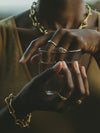 Woman stacking multiple Ouroboros Rings in white and yellow solid gold by Pola Jewellery — gender-neutral snake rings symbolising eternal love, perfect for ring stacking, handcrafted in Barcelona.