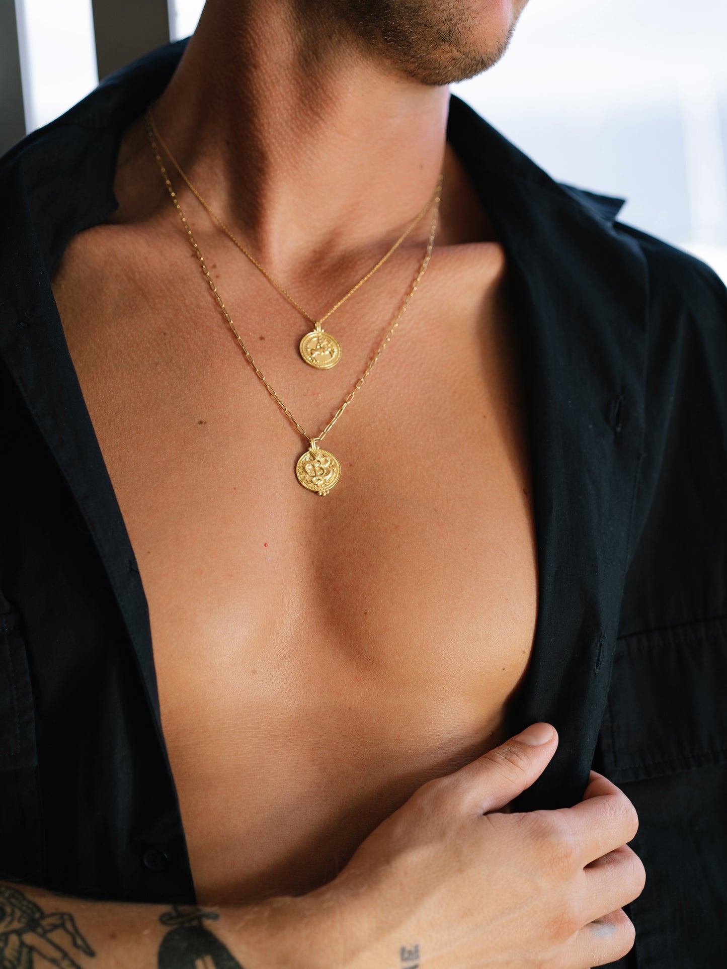 Male model wearing the Sagittarius zodiac necklace by Pola Jewellery – handcrafted in solid 18k gold with Evil Eye detail. A gender-neutral astrology pendant designed for everyday power.
