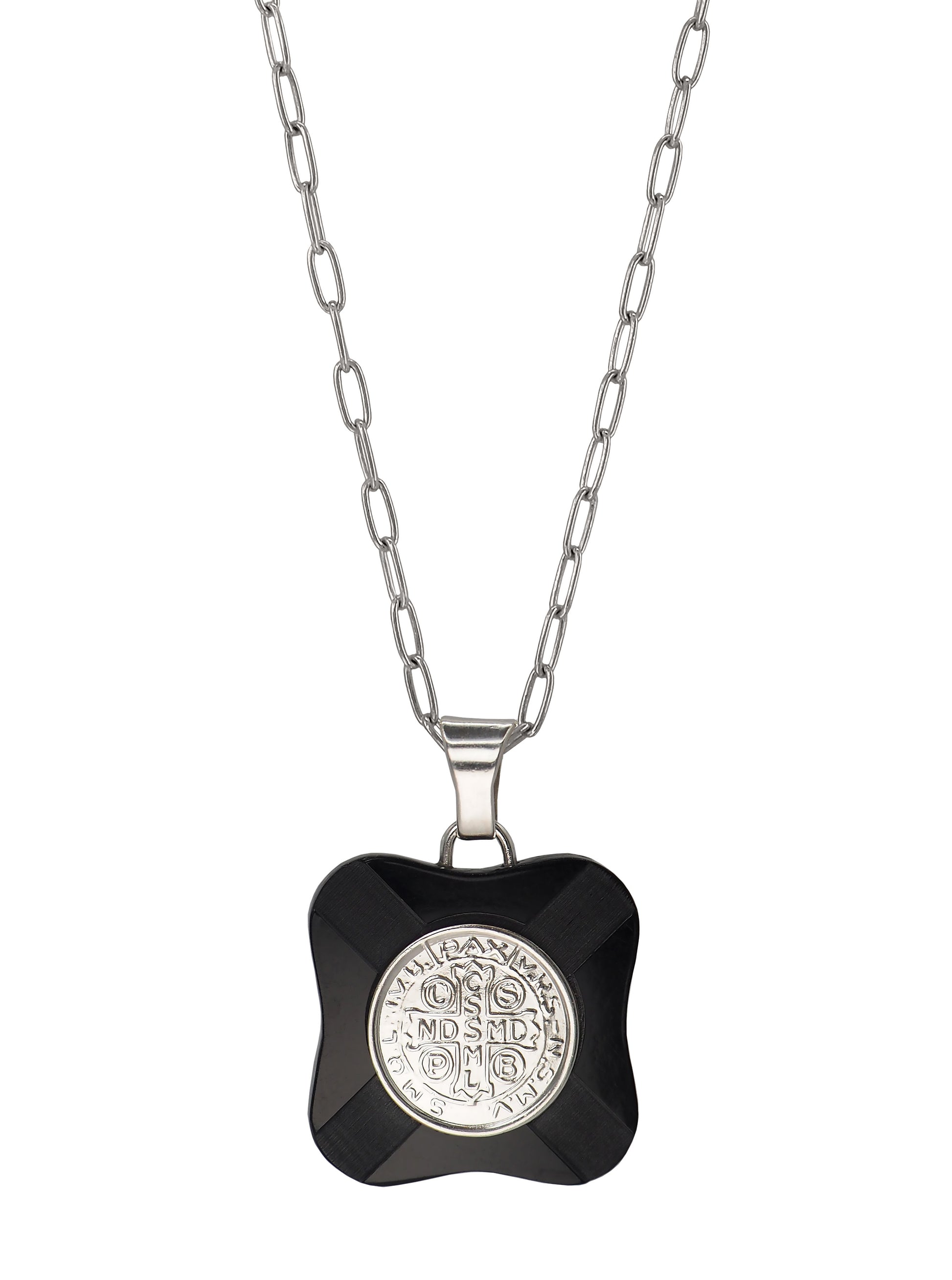 Close-up of vintage St. Benedict pendant with Latin inscription in silver and black Bakelite.