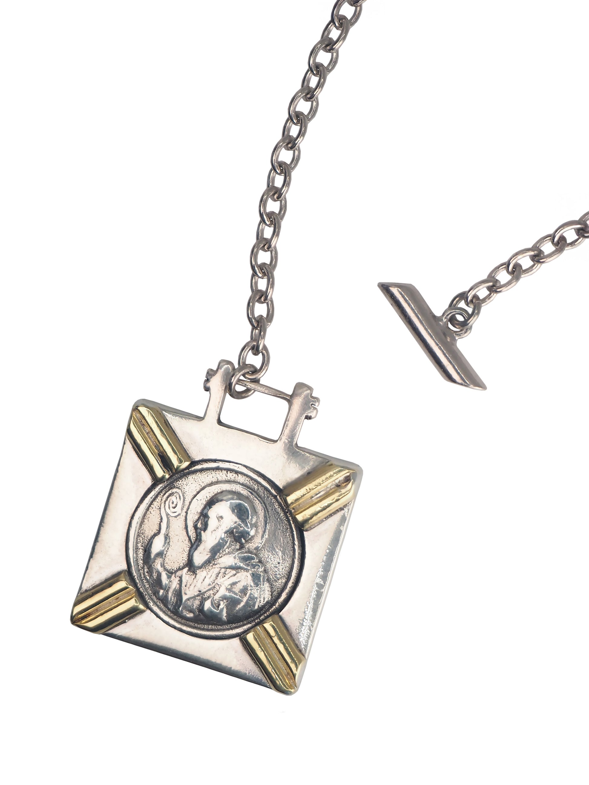 Close-up of square St. Benedict pendant with Latin inscription on bold silver chain.