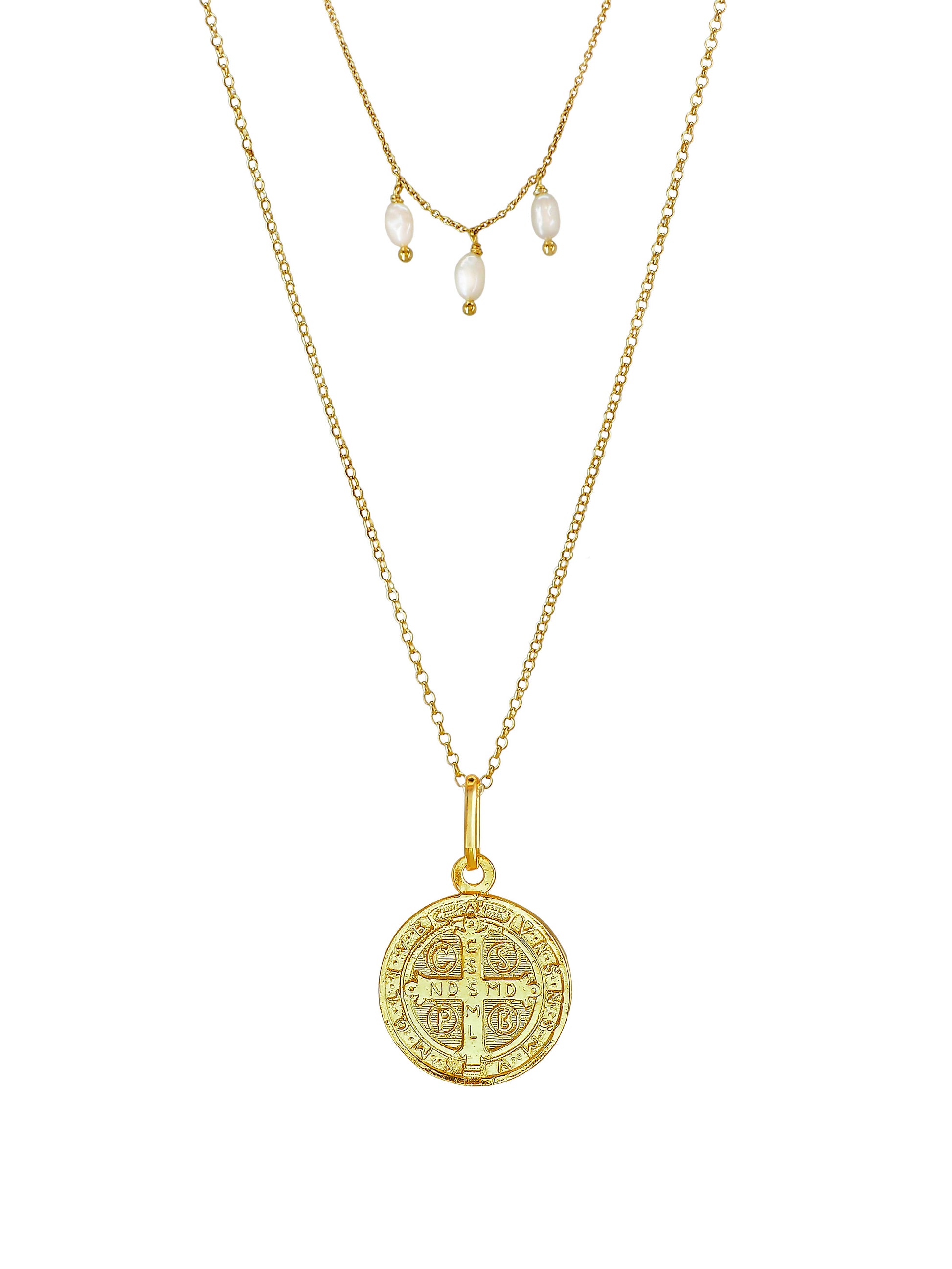 Close-up of St. Benedict medallion with engraved cross and Latin text on gold-plated sterling-silver necklace with pearls.